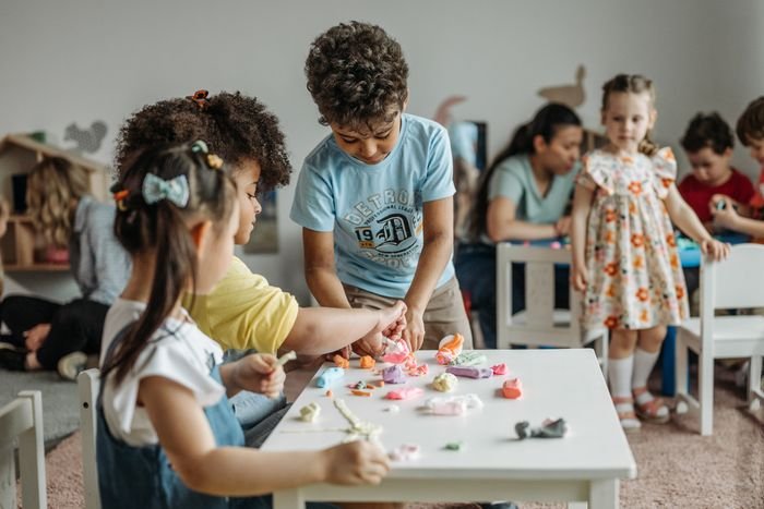 Children shaping modelling clay at a low table