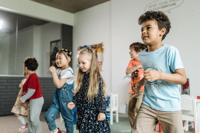 Children dancing and moving together in a classroom