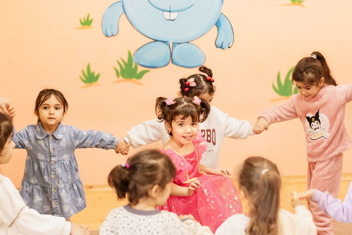 Children holding hands in a circle during a group game